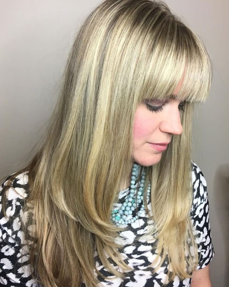 Long straight hair with blunt bangs, a bold and trendy 2025 haircut gaining popularity among sleek style lovers in the USA.