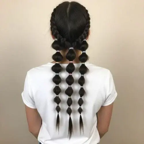 Woman with trendy 2025 bubble braids styled with colorful elastics