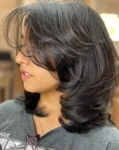 Medium-length straight hair with feathered ends, a soft and stylish haircut trend for 2025 in the USA.