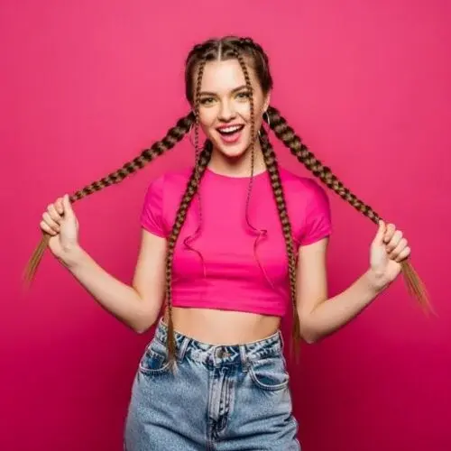 Woman wearing soft French pigtail braids with loose, styled tendrils
