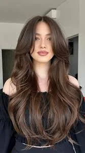 Layered long straight haircut with curtain bangs, one of the best 2025 hair trends in the USA for dimension and face-framing style.