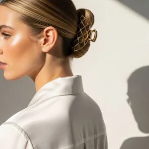 Sleek low bun with gold geometric hair barrette, styled in modern editorial fashion