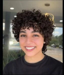 Woman with Pixie Cutie Curl, a short, chic curly haircut showcasing natural texture and volume, trending for 2025.