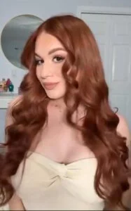 Woman with tapered curly cut, short sides and voluminous top, trending curly hairstyle for 2025.