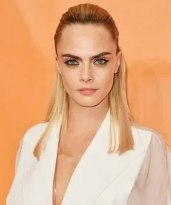 Cara Delevingne with a blonde crop and shadow root, a bold celebrity short hairstyle trending in 2025.