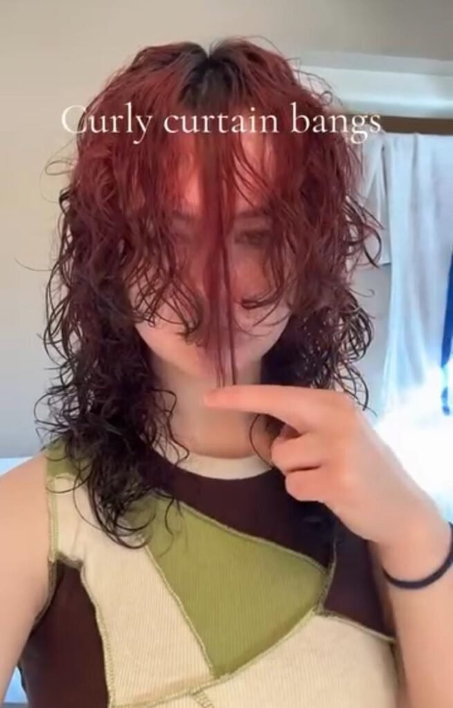 Woman with curly bangs hairstyle, soft face-framing curls trending in 2025.